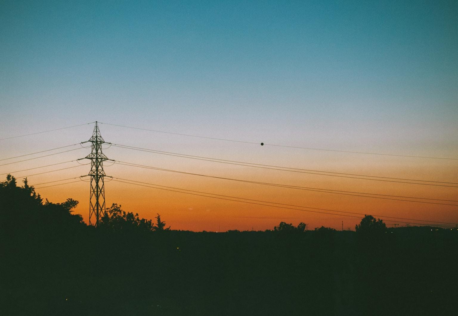 A vivid sunset in Istanbul with power lines silhouetted against a colorful sky.